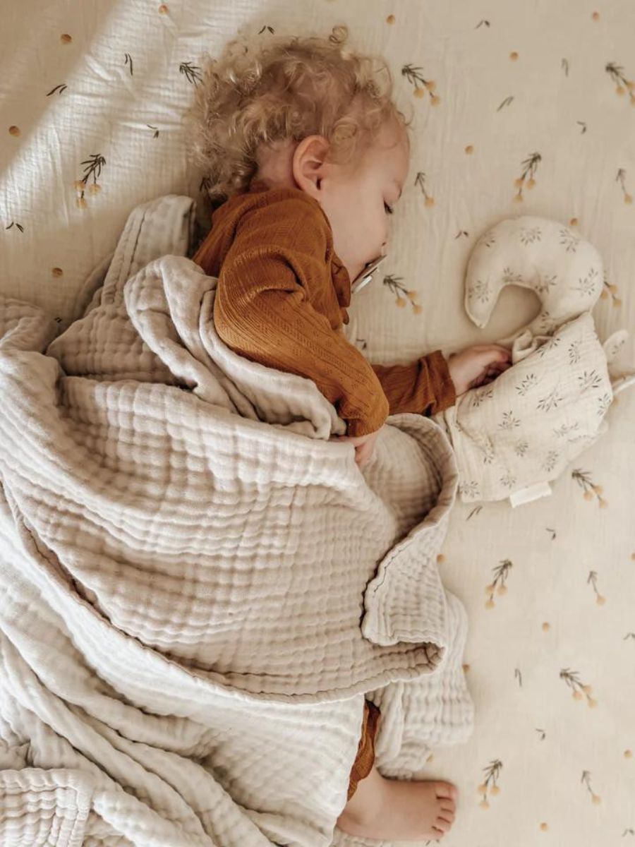 The Softest GOTS Organic certified baby bassinet sheets with a vintage scandi design and Asutralian yellow billy button flowers on a neutral background