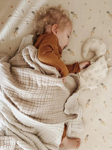 The Softest GOTS Organic certified baby bassinet sheets with a vintage scandi design and Asutralian yellow billy button flowers on a neutral background